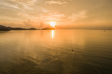 Obraz premium Sunrise at the sea and fishing boats in Phuket, Thailand. Aerial view from flying drone