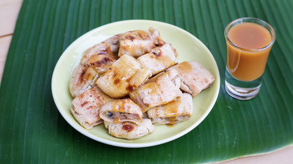 Grilled banana and sweet topping on banana leaves (Thai dessert).