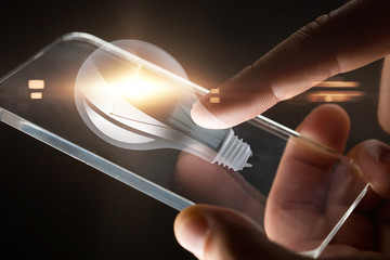 hands with smartphone and lightbulb projection