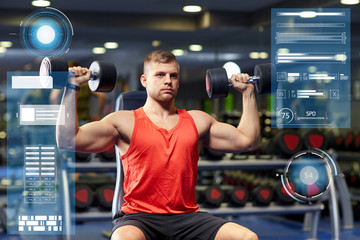 young man with dumbbells flexing muscles in gym