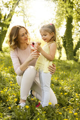 Obraz premium Mother and daughter in the meadow with ice cream.