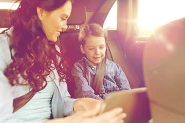 happy family with tablet pc driving in car