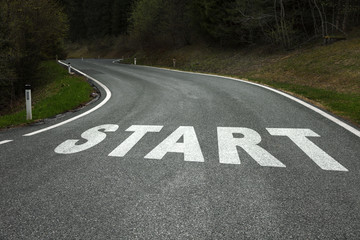 Start word message on the winding curved asphalt country road.