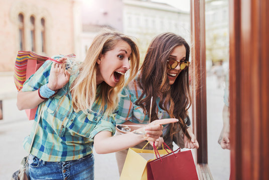 Happy young women in shopping. Consumerism, fashion, lifestyle concept