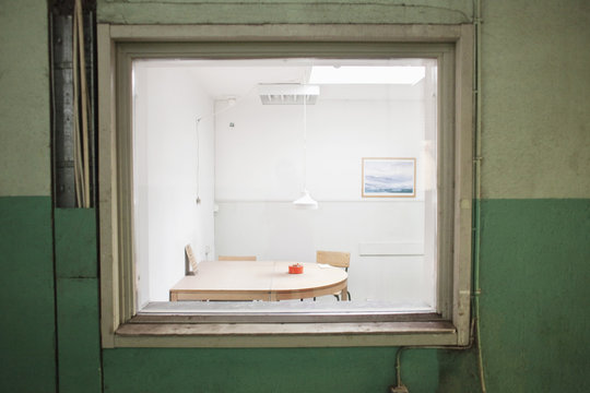 Empty chairs with table seen through window