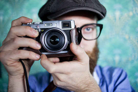 Close-up of man photographing through camera against wall