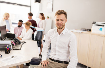 happy young man over creative team in office