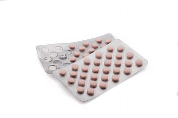 Old medicinal pink pills with expired shelf life on a white background. Isolated