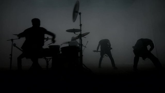 Rock music concert. Rock band concert. Silhouettes of rock group on concert stage. Music band show. Music concert. Musical performance rock group. Musical group