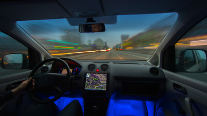 The man drive a car on the evening road. Inside view. Wide angle