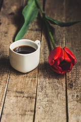 Coffee in a cup and tulips on a table