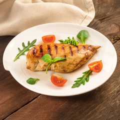 Grilled chicken fillet with cherry tomatoes and salad leaves