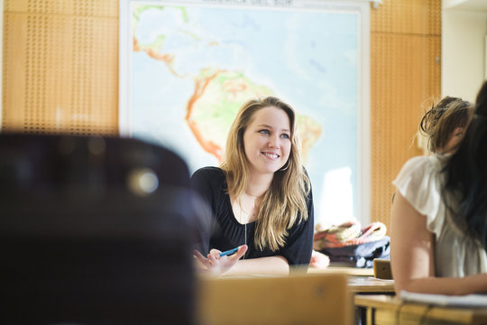 Happy high school student sitting at classroom