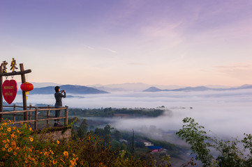Tourist with Sunrise and sea of clouds over Pai District Mae Hong Son, THAILAND. View from Yun Lai Viewpoint is located about 5 km to the West of Pai town centre above the Chinese Village.