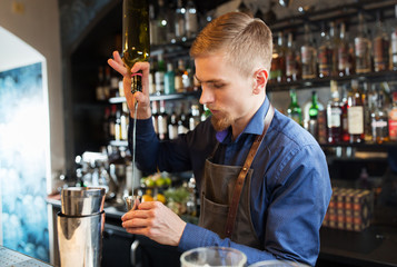 barman with shaker preparing cocktail at bar