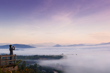 Tourist with Sunrise and sea of clouds over Pai District Mae Hong Son, THAILAND. View from Yun Lai Viewpoint is located about 5 km to the West of Pai town centre above the Chinese Village.