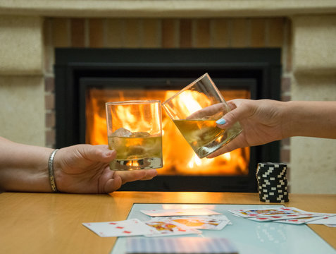 Rest by the fireplace with a glass of whiskey while playing poker