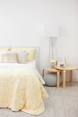 Fototapeta na wymiar Comfortable bed with coverlet in light bedroom interior