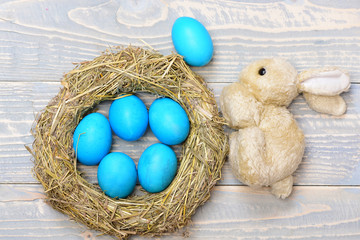 traditional eggs painted in blue color inside woven straw wreath