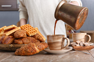 Breakfast with black coffee, freshly baked waffles and croissants