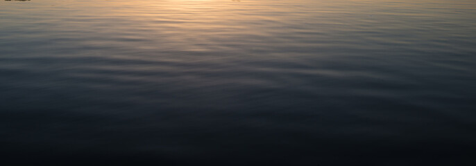 Water surface with sunrays reflections