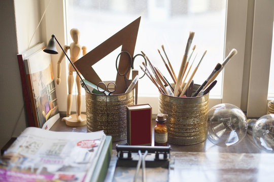 Paintbrushes in desk organizer on table