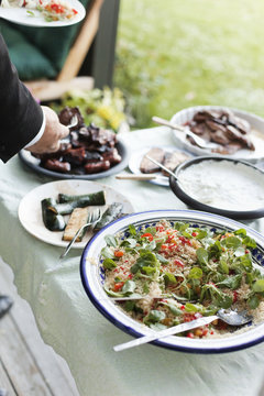 Cropped hand of man serving food at outdoor dining table
