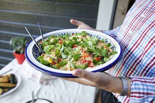 Midsection of man holding salad plate at yard