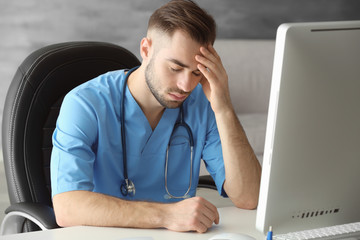 Tired medical assistant in his office