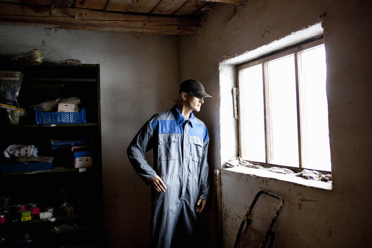 Repairman standing near window in abandoned building