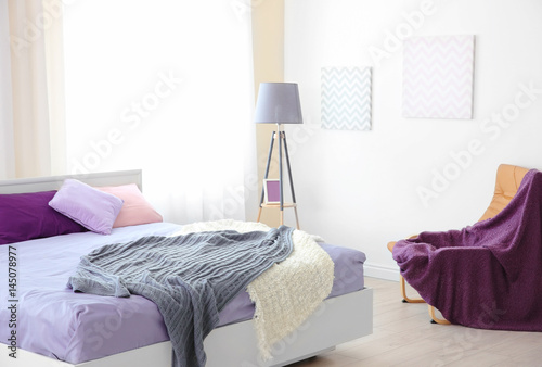 "Interior of light modern bedroom with lilac bedding" Stockfotos und