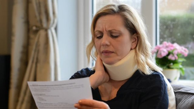 Mature Woman Reading Letter After Receiving Neck Injury