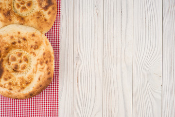 Uzbek bread on old white wooden table.