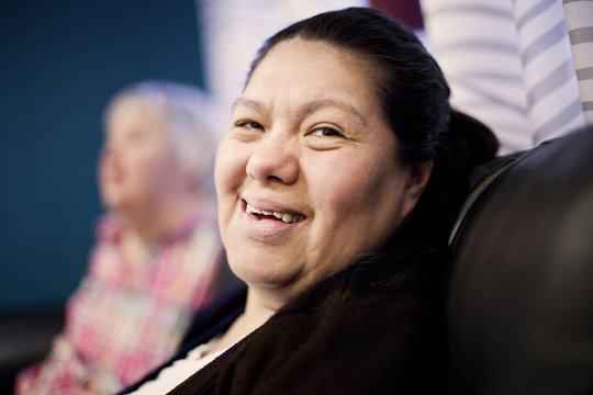 Close-up portrait of smiling woman with down syndrome resting at nursing home