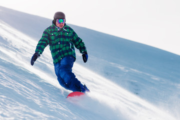 Fototapeta na wymiar snowboarder is riding from snow hill