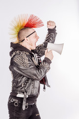 Portrait of punk rocker holding shouting with a megaphone against a white background.