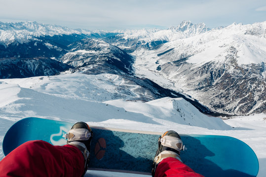 snowboarder with snowboard is sitting on the mountain