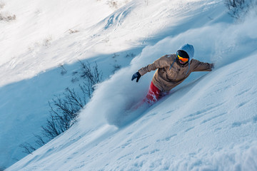 snowboarder is riding from snow hill