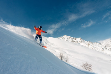 Naklejka na ściany i meble snowboarder is riding from snow hill