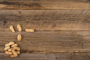 Peanuts on the background of the old wooden table.