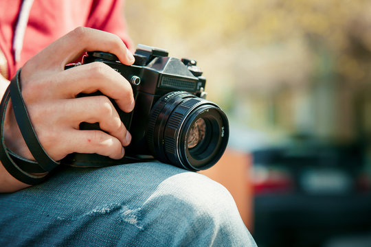 Vintage camera in hand on blurry backround