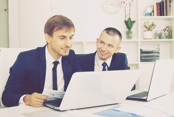 Obraz premium Colleagues working together with laptops