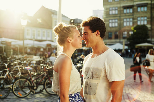 Romantic couple rubbing noses on city street