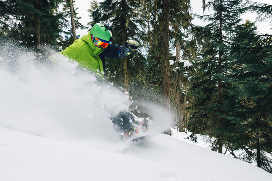 snowboarder with special equipment is riding and jumping very fast in the mountain forest
