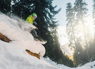 snowboarder with special equipment is riding and jumping very fast in the mountain forest