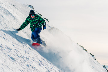 snowboarder is riding down from snow hill