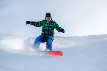 Fototapeta na wymiar snowboarder is riding from snow hill