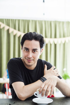 Portrait of smiling young man holding coffee cup