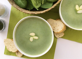 Vegetable spinach soup with almonds and wholemeal bread. Top view.