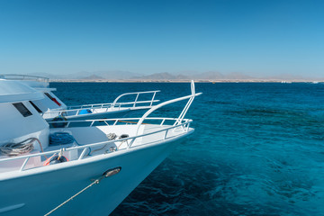 View at the coral sea and white yacht. Perfect place for snorkeling. Summer vacation at Red sea with turquoise clear water.